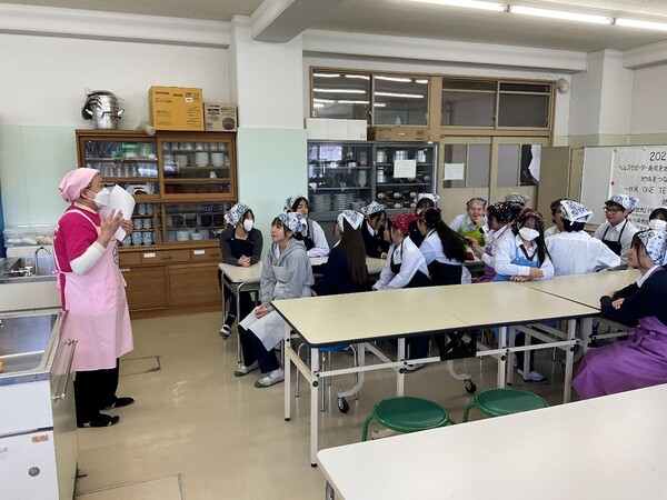 調理台の前で説明を受ける生徒たち