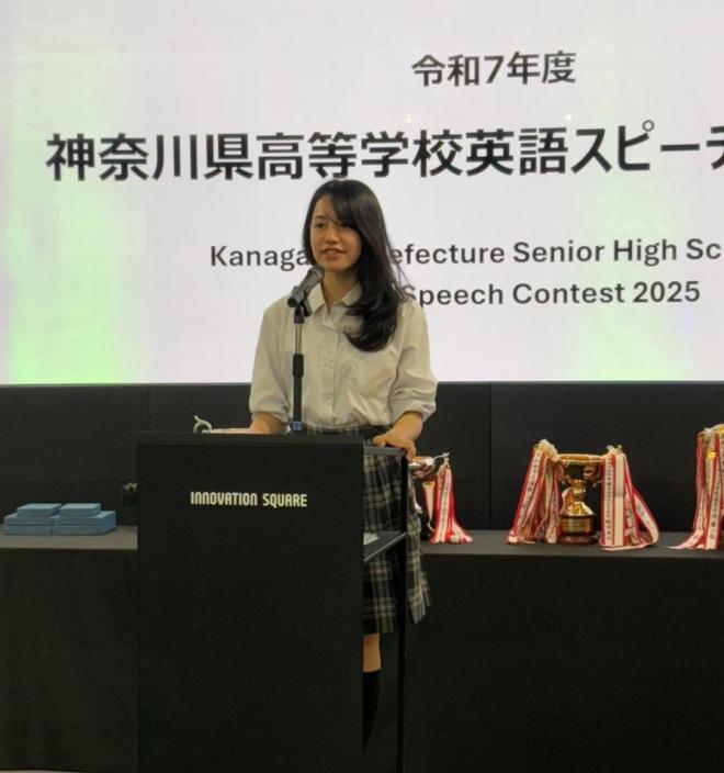 ステージに立って発表する部長