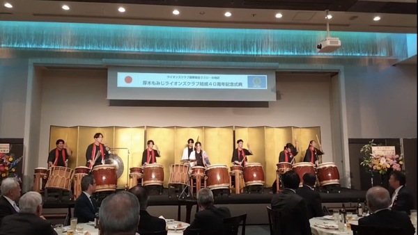 金色の屏風の前で演奏する和太鼓部員たち