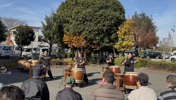 屋外にて観客の前で力いっぱい演奏する様子