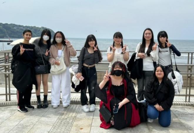 海岸沿いで記念撮影をする生徒たち