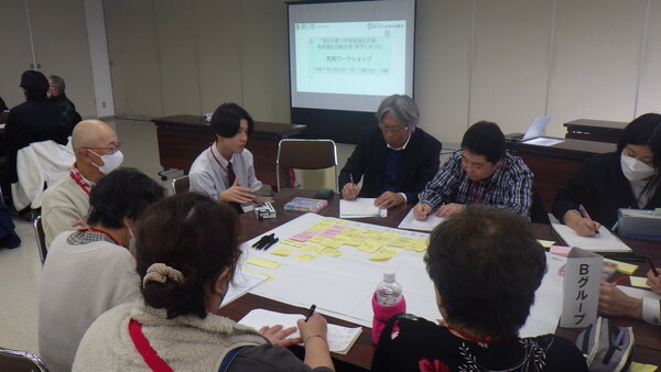 机を囲んで住民とグループワーク