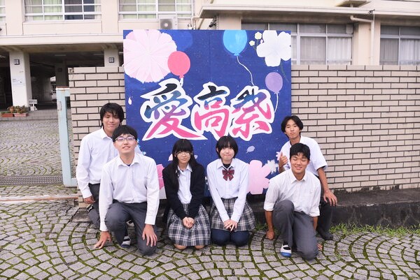 看板の前で記念撮影する生徒会役員たち