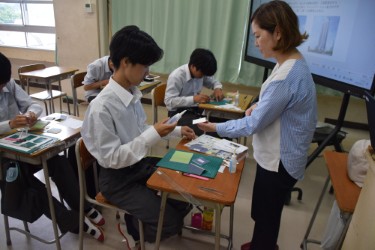 机に向かって建築模型を作る生徒たち