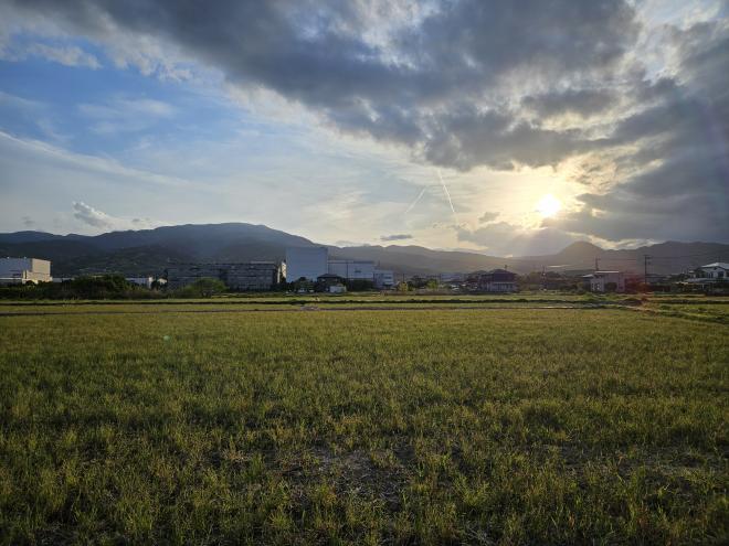 山際に沈みゆく夕日を中心に、手前の草原と夕日から広がるダイナミックな雲を広角で撮影しました。