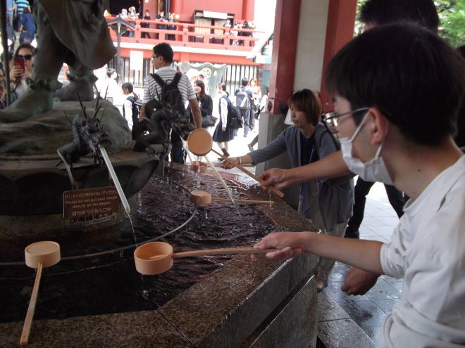 浅草寺の手水鉢で手を清める様子の写真