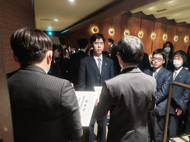 松本部会長から表彰状を受け取る場面